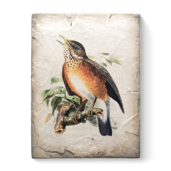 A white sculptural block with a vintage painting of a robin standing on a branch with its beak open on it.